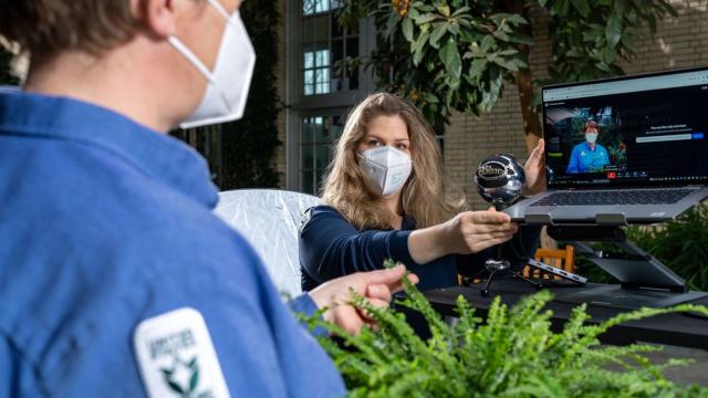 Grace Anderson adjusts the camera and laptop for an online horticultural education program.