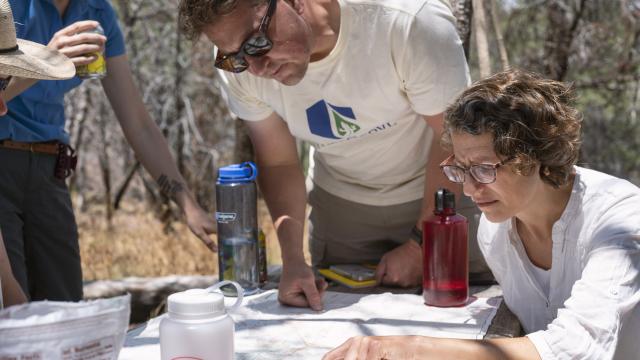 three people look at a map