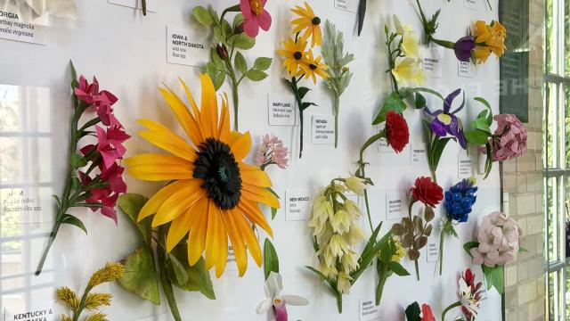 Artist-created flowers made from paper include a yellow sunflower, red rose, red carnation, and dozens more
