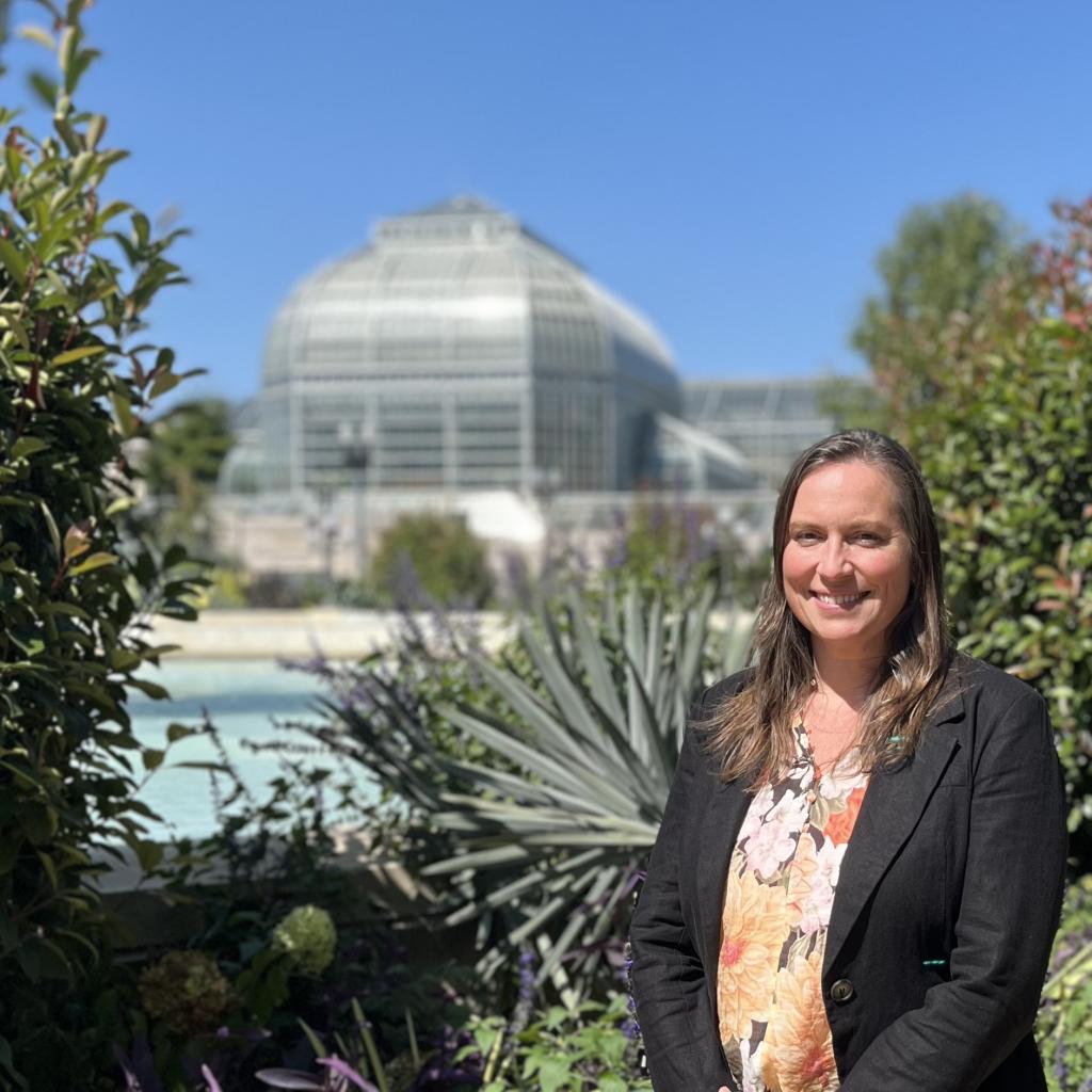 Megan Haidet stands in front of a large Conservatory