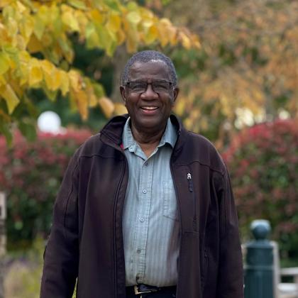 Terry Nicholls standing outside amongst yellow and red leaves